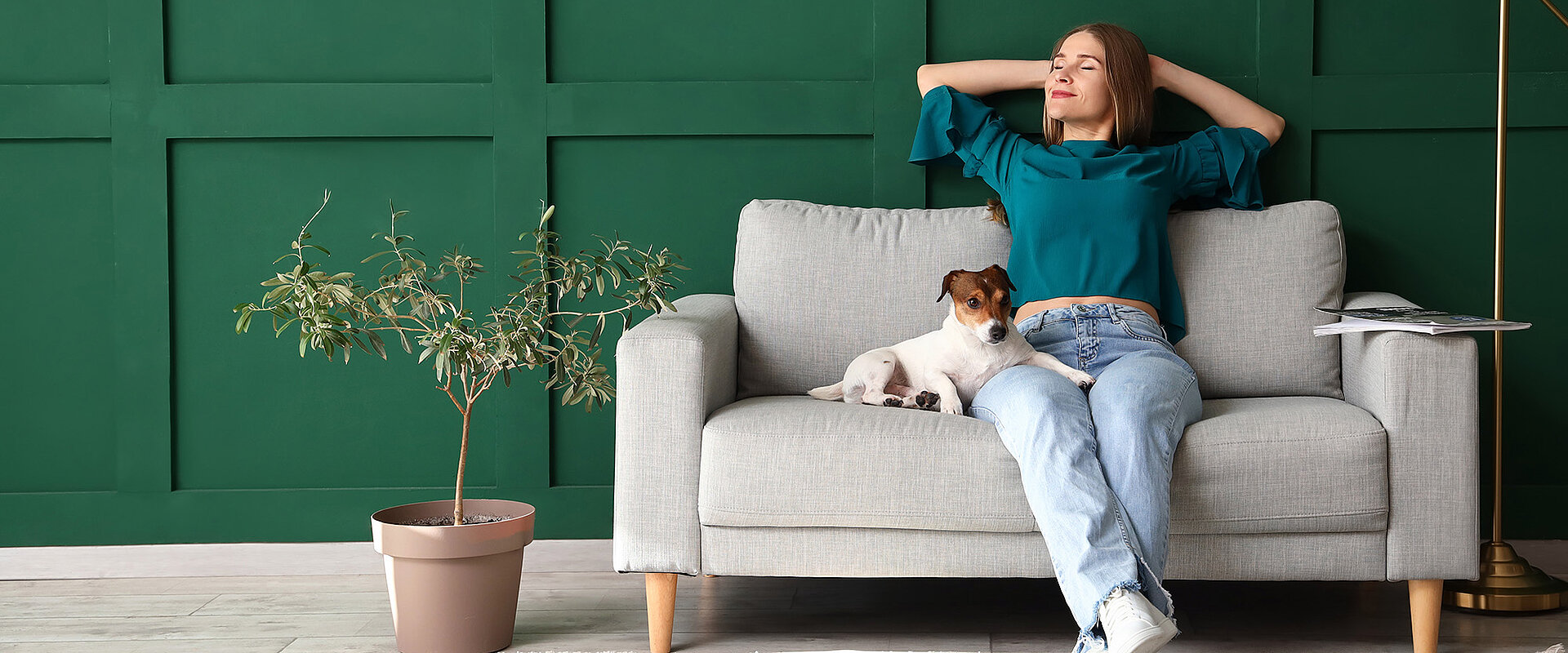 Eine entspannte Frau mit Hund auf einem Sofa
