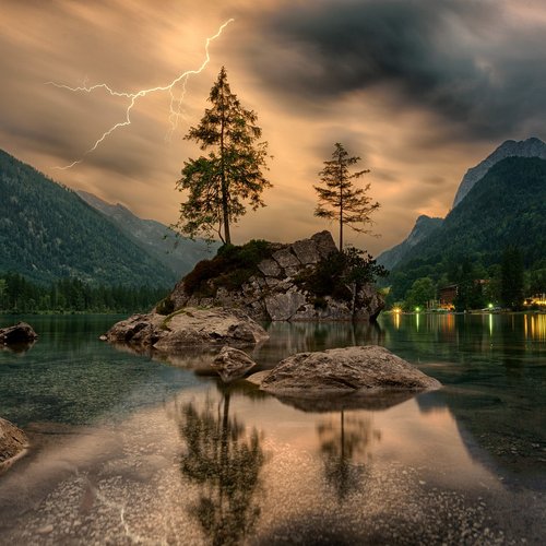 Ein düsteres Bild von einem See mit einer Felseninsel in der Mitte mit 2 Nadelbäumen darauf. Im Hintergrund gewittert es.